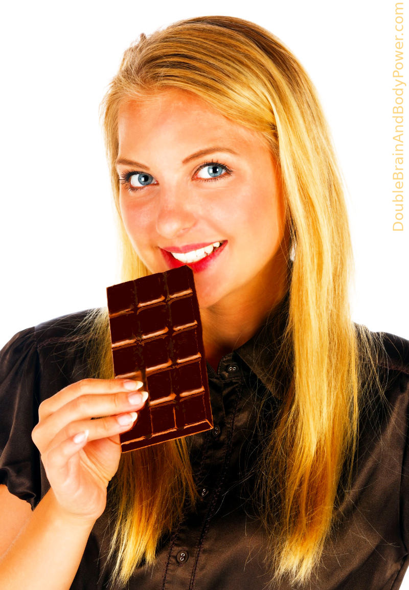 A lovely long haired blond lady with blue eyes is holding a delicious dark chocolate bar.